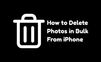 A hand holding an iPhone showing a grid of photos with multiple blue checkmarks selected, illustrating how to delete photos in bulk from iPhone.